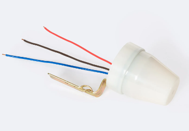 sensor crepuscular con capacidad de encender o apagar automáticamente la luz según la luz ambiental. Es adecuado para uso en exteriores y se monta en superficie, ya sea una pared o en el mismo poste de la luminaria.
Este Sensor Crepuscular Superficie 10A IP44 puede soportar una potencia LED de 2400W con una corriente nominal máxima de 10A. Tiene una clasificación IP44, lo que lo hace resistente a la entrada de polvo y agua. Además, funciona con una tension de 220V-240V y una frecuencia de 50/60Hz.